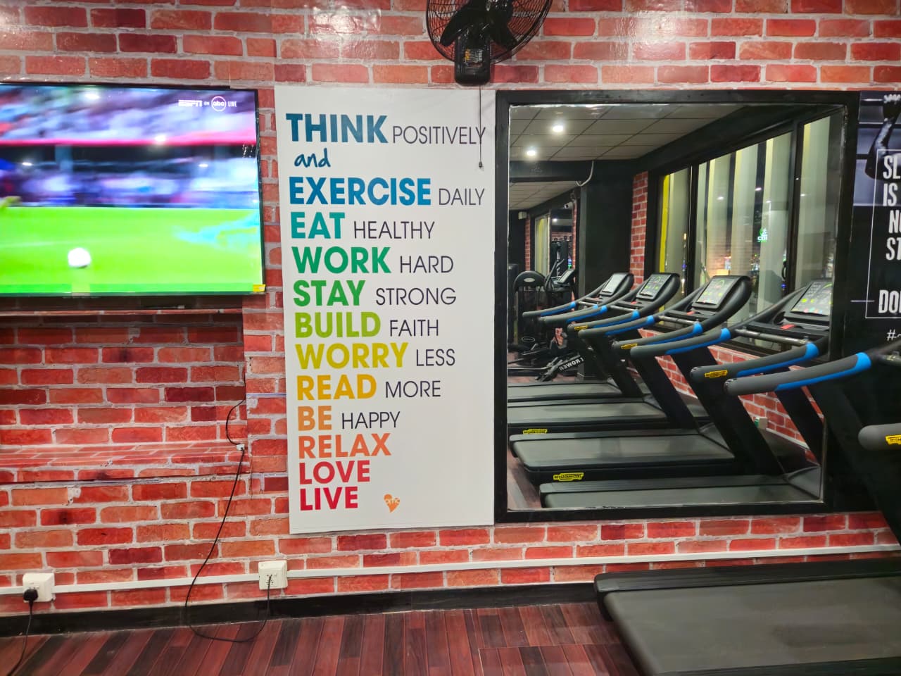 Row of treadmills against the brick wall at Core Fitness Lahore