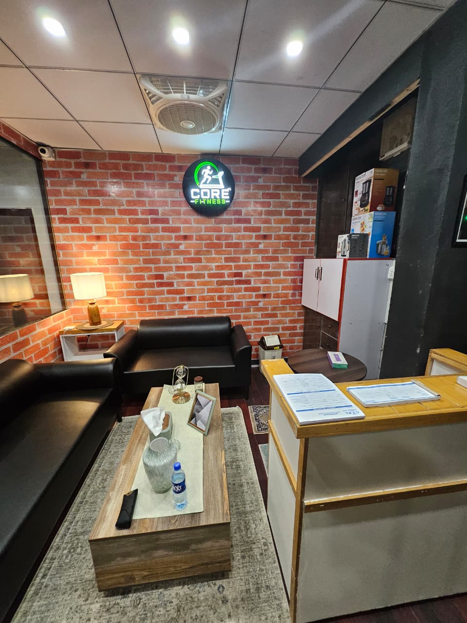 Reception lounge with sofas and the neon Core Fitness sign